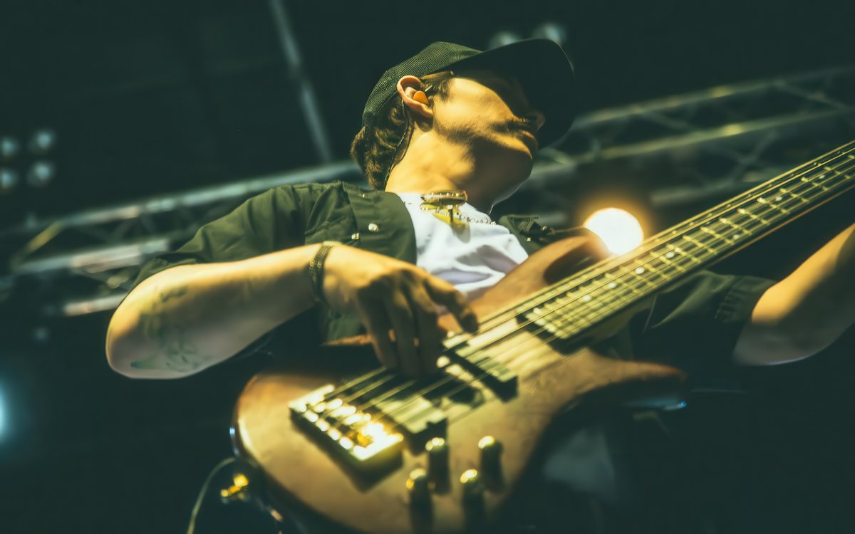 Dan Beattie mid-song on five-string bass under gold stage light