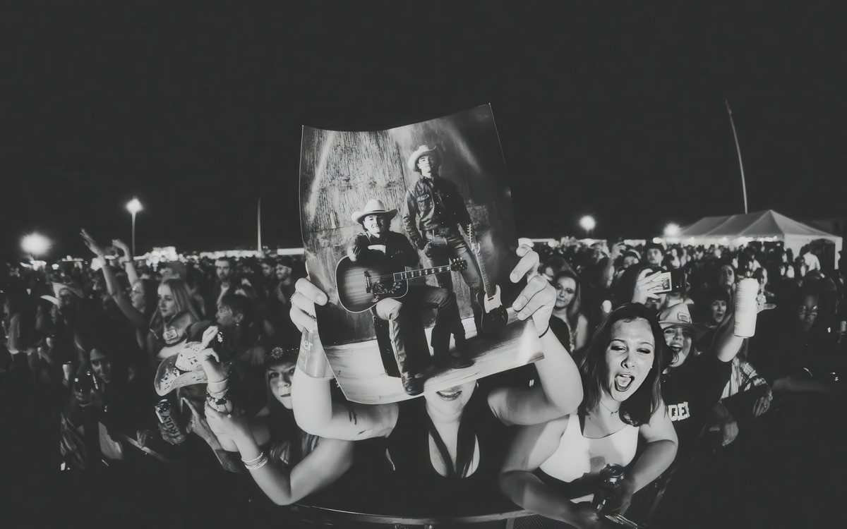 Fans in the front row holding up a Martin Boys poster