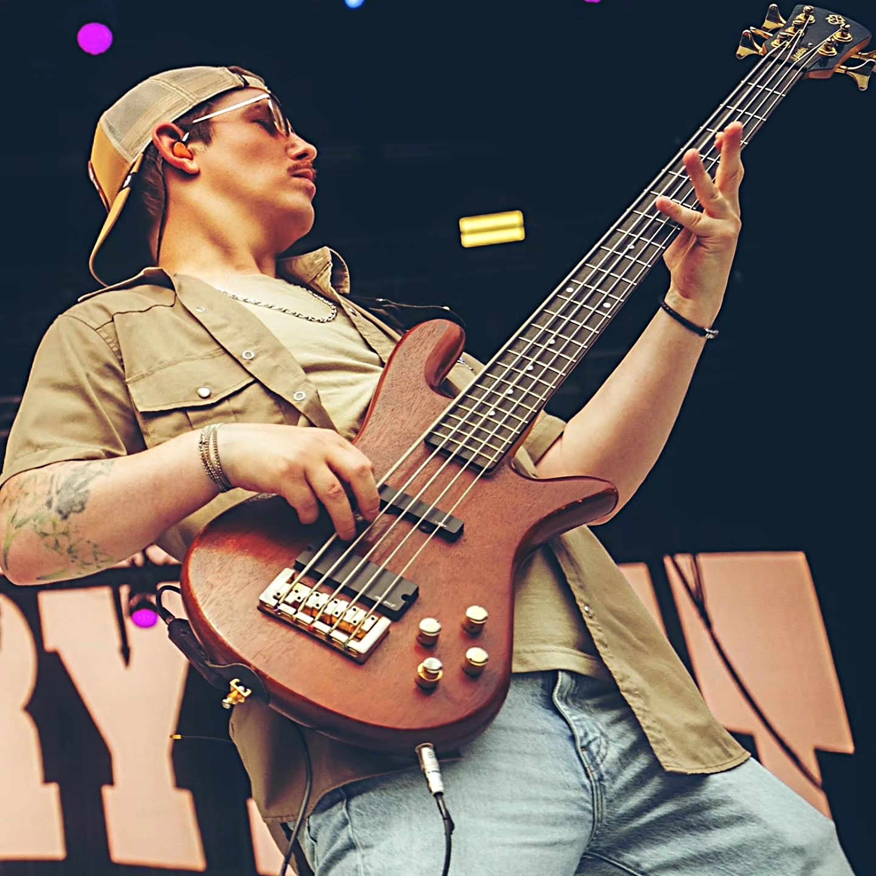 Dan Beattie mid-set at an outdoor festival, five-string bass raised